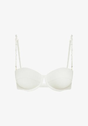 White bra with ribbed texture, underwire cups, and decorative pearl accents on clear straps. Adjustable back closure for fit.