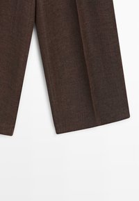 Pantalon marron à jambes larges avec un ourlet droit sur fond blanc, montrant les détails de texture et de couture.