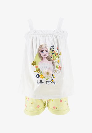 Biały top na ramiączkach z elastycznymi paskami, z kwiatowym wzorem i napisem "Cześć Wiosno". W zestawie z jasnobeżowymi szortami w kwiaty.