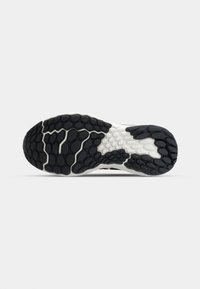 Black and white sneaker outsole featuring a hexagonal pattern for grip, with a smooth, rubbery texture and white accents.