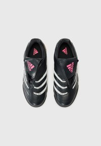Sorte Adidas sportssko med hvite striper, rosa Adidas-logo på tunge og innleggssåle, sett ovenfra på hvit bakgrunn.