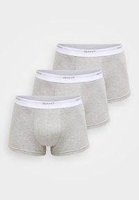Trois paires de boxers gris en coton doux. Chaque paire possède une ceinture élastique blanche avec le logo "GANT".