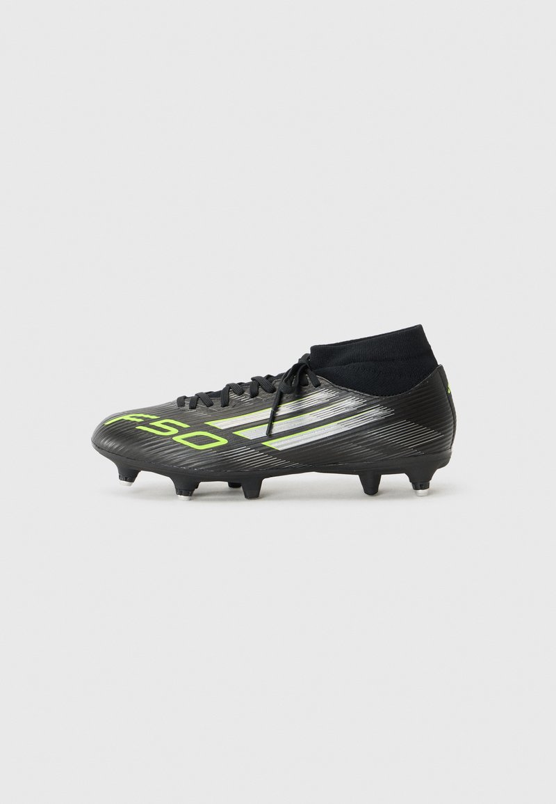 Zwarte voetbalschoenen met groene en zilveren details, voorzien van een hoge enkeldesign en zes studs op de buitenzool voor grip.