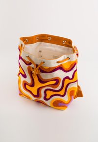 EEN BUCKETBAG MET VIBRERENDE ORANJE, PINK EN PAARS ABSTRACTE PATROON OP EEN CRÈME ACHTERGROND. HEEFT EEN SOLIDE ORANJE STOF RAND EN TREKKOORD SLUITING.
