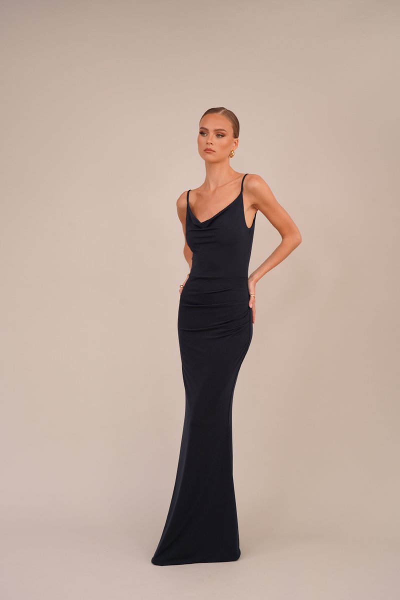 Vestido longo, ajustado, azul-marinho, com decote drapeado e alças finas; tecido suave com detalhes de franzido na cintura que valorizam a silhueta.