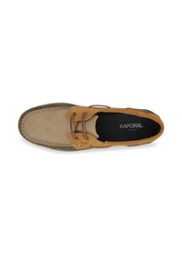 Zapato de barco de cuero en tono marrón y beige con detalles de costura, cordones decorativos y una plantilla negra con la marca "KAPORAL".
