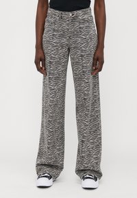 Zebra print wide-leg jeans in gray and black, featuring a high waist, front pockets, and a button closure. Made of lightweight fabric.