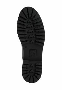 Černá gumová podrážka s hlubokými drážkami a cikcak vzory. Obsahuje logo značky a velikostní razítko. Odolný design pro trakci a stabilitu.