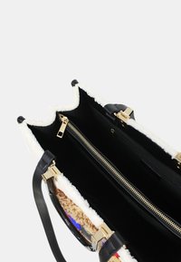 Borsa a mano in pelle nera con rifiniture in pelliccia sintetica bianca, dotata di hardware dorato, una tasca con zip e due scomparti principali. Manici lunghi neri.