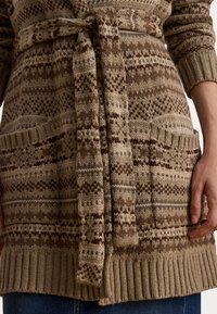 Cardigã de malha em tons de bege com padrões geométricos castanhos, apresentando uma cintura atada, punhos canelados e dois bolsos frontais.