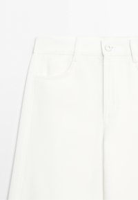 White denim skirt with front pockets, belt loops, and a button closure at the waist.