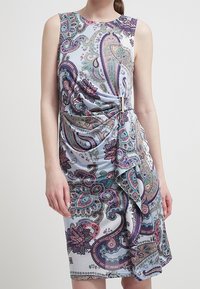 Ärmlös klänning i ljusblått med paisleymönster i lila, rosa och grönt. Rynkad detalj vid midjan ger textur och form.