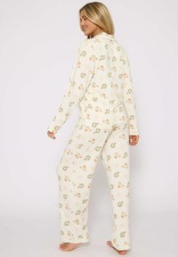 Leichtes Cream-Pyjama-Set mit floralem und Seesternmuster, langen Ärmeln und locker sitzenden Hosen. Glattes, weiches Material.