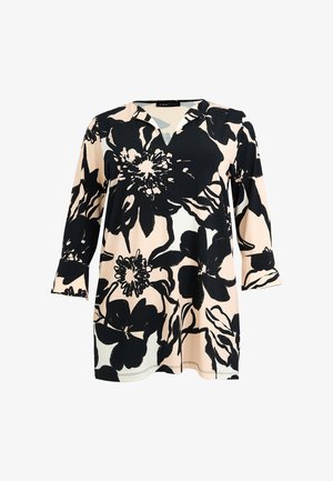 Tunique beige à manches longues avec grand motif floral noir, col en V, et poignets légèrement évasés.