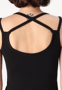 Black tank top featuring crossback straps, a scoop neckline, and a smooth texture, exposing the back with a rounded cut-out design.