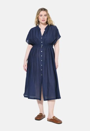 Marineblaue Midi-Kleid mit Knöpfen, kurzen Ärmeln und tailliertem Schnitt. Leichter, strukturierten Stoff mit geradem Schnitt und seitlichen Schlitzen.