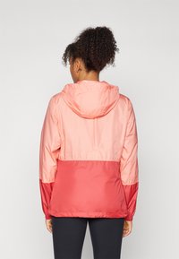 Lightweight, two-tone windbreaker in coral and pink. Hooded, with elastic cuffs and a cinched waist. Smooth, water-resistant fabric.