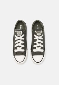 Baskets en toile noire avec embout en caoutchouc blanc, lacets et détails blancs. Logo "Converse All Star" sur la languette. Design à tige basse.