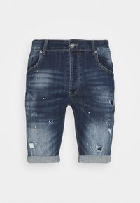 Pantalones cortos de mezclilla con un lavado azul oscuro, detalles desgastados y dobladillos enrollados. Presenta salpicaduras de pintura dispersas en blanco y naranja.