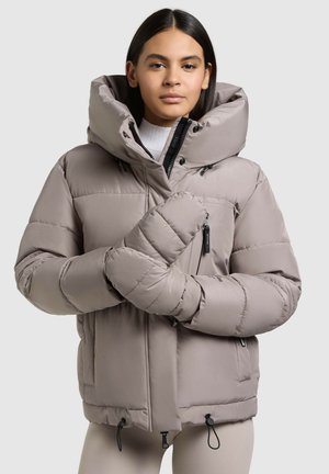 Puffer jacket in light beige with a high collar, front zipper, zippered pockets, and adjustable cords at the hem. Features a padded texture.