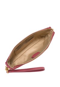 Pochette en cuir rouge profond avec une fermeture éclair dorée, un intérieur lisse comprenant des fentes pour cartes de crédit et une sangle de poignet amovible.