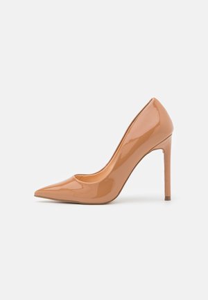 Glänzender Pumps aus nudefarbener Lackleder mit spitzer Zehenpartie und 10 cm hohem Stiletto-Absatz, ausgestattet mit einer glatten Oberfläche und minimalistischem Design.