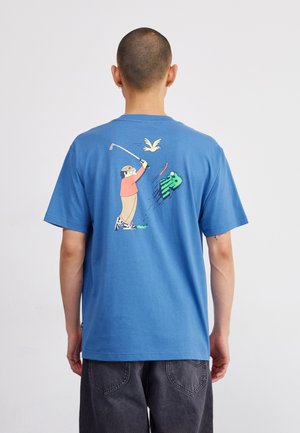 Blaues Baumwoll-T-Shirt mit kurzen Ärmeln. Grafisches Design auf der Rückseite zeigt eine Person beim Golfspiel, mit einem Vogel darüber und grünen Grasakzenten.