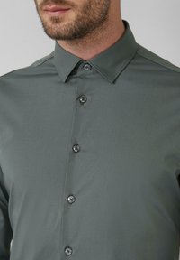 Button-up Hemd in muted Grün, aus glattem Stoff, mit einem Kentkragen und sechs passenden Knöpfen auf der Vorderseite.