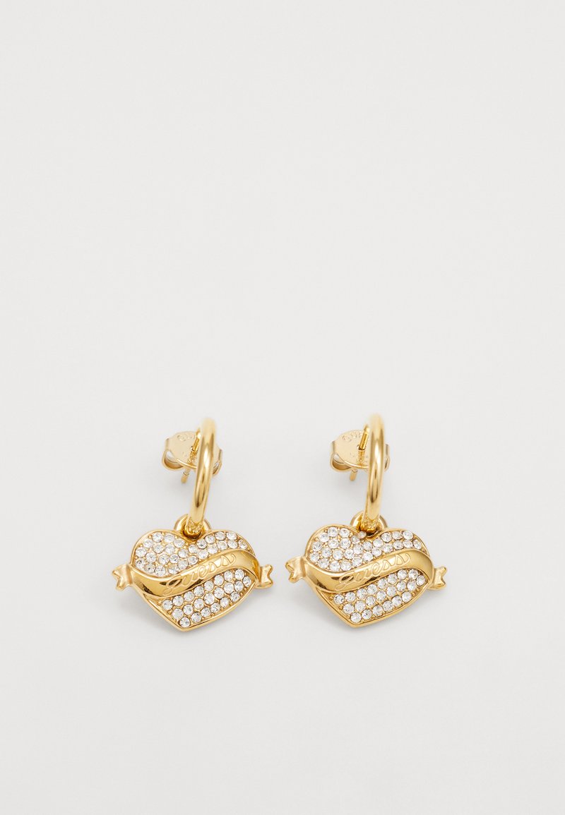 Guldörhängen med hjärtformade hängande detaljer prydda med klara rhinestones, utförda med ett banddetalj som är graverad med "access."
