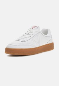 Witte leren sneaker met een gestructureerde zool van gumrubber, voorzien van vetersluiting en een subtiel zijlogo in grijs. Driehoekig rood embleem op de tong.