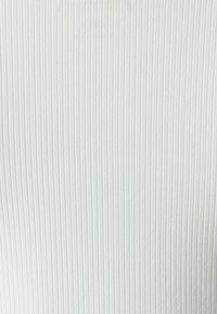 White ribbed fabric with fine vertical lines, soft texture, and a smooth finish. No visible patterns or hardware details.