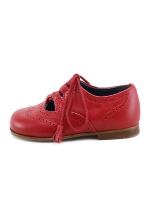 Zapato oxford infantil de cuero rojo con patrón perforado, detalles recortados, cordones atados en un lazo y una suela plana marrón.