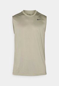 Bezrękawnik sportowy w stonowanej oliwkowej zieleni, wykonany z lekkiego materiału. Posiada małe czarne logo Nike na lewej piersi.