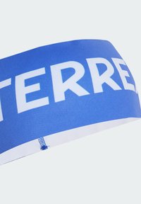 Modrá elastická čelenka s výrazným bílým textem. Hladký povrch, dobře padnoucí design, s bílou spodní stranou a drobným detailem šití.