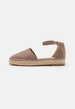 Brown suede espadrille with a woven jute sole, low heel, and ankle strap. Features a rounded toe and open sides for breathability.