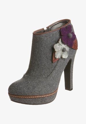 Bottine en feutre gris avec un talon haut, ornée d'une bande marron et d'accents floraux en feutre violet et blanc. Doublure intérieure lisse.