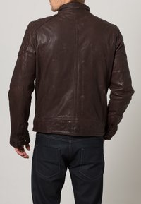 Hnědá kožená bunda s hladkou texturou, vybavená vysokým límcem, přiléhavými rukávy a jemným šitím na zádech.