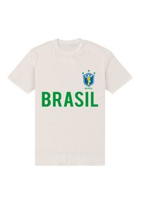 Biała koszulka z bawełny z zielonym napisem "BRASIL" oraz niebieskim logo CBF z trofeum i gwiazdami na lewej piersi.