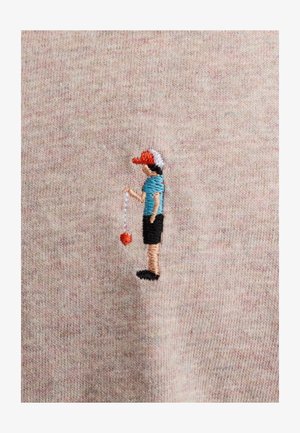 Geborduurd figuur van een persoon die een rode pet, een blauw shirt en een zwarte korte broek draagt, en een rode bal aan een touw vasthoudt tegen een lichte stof.