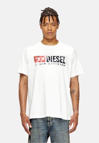 Hvid tee-shirt i bomuld med et stort rødt og sort "DIESEL" grafisk tryk på forsiden, med korte ærmer og løs pasform.