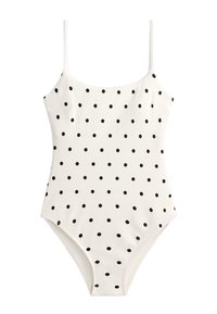 Biele jednodielne plavky s tenkými ramienkami a rovnomerne rozloženými malými čiernymi bodkami po celej látke.