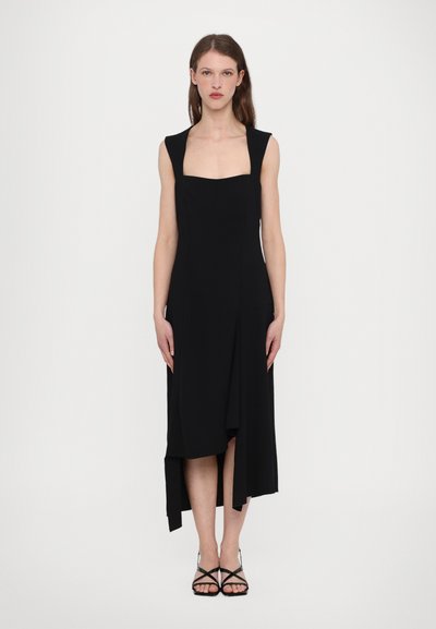 Black sleeveless dress with a square neckline, asymmetrical hem, and a soft drape. Smooth texture and minimalist design are featured.