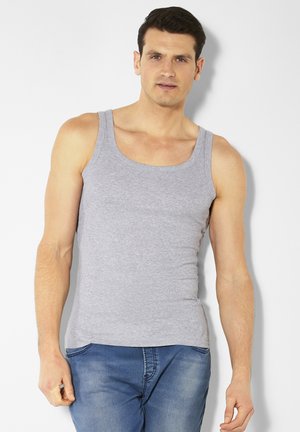 Gray cotton tank top with a scoop neckline and wide shoulder straps, fitted design, worn with blue denim jeans.