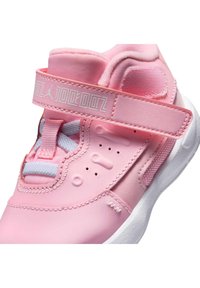 Różowe sneakersy z gładkiego materiału, z wyściółką przy kostce, regulowanym paskiem, teksturowanymi akcentami oraz białą podeszwą. Widoczne wzmocnione szwy.