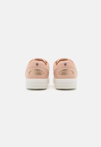 Rosa sneakers i läder med vita gummisulor, med rund form, texturerade detaljer och synliga sömmar vid hälen.