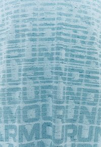 Vaaleansininen teksturoitu kangas, johon on painettu toistuvia graafisia kuvioita ja kirjaimia, luoden kerroksellisen ja dynaamisen ilmeen. Pehmeä ja tasainen materiaali.