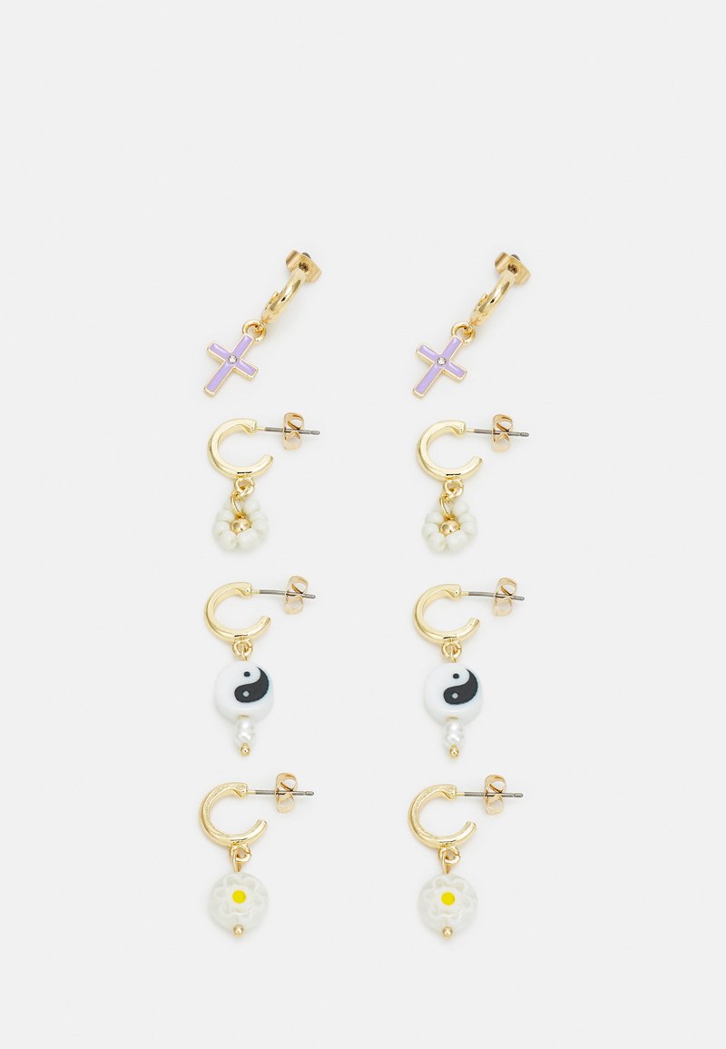 Brincos em tom de ouro com um cruz roxa, símbolo yin-yang, flores brancas e detalhes em pérolas. Vários designs disponíveis em estilos de argola e com pingentes.