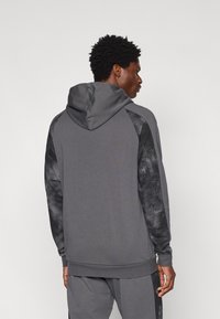 Γκρι φούτερ με κουκούλα, με υφή στις μαύρες μανσέτες και ριμπ μανσέτες, διαθέτει χαλαρή εφαρμογή και ρυθμιζόμενη κουκούλα με κορδόνι.