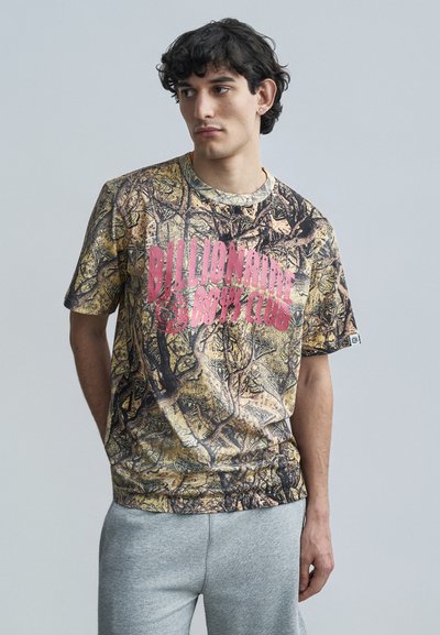 Short-sleeve T-shirt in camo pattern with shades of brown and black; features large pink "Billionaire Boys Club" print on front.