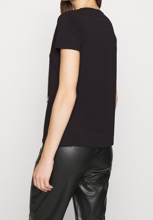 Sort t-shirt med korte ærmer og en afslappet pasform, lavet af blødt stof. Let buet kant og uden synlige mønstre eller grafik.